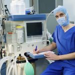 Bild mit medizinischem Gerät und einem Arzt, der einen Papierbogen ausfüllt